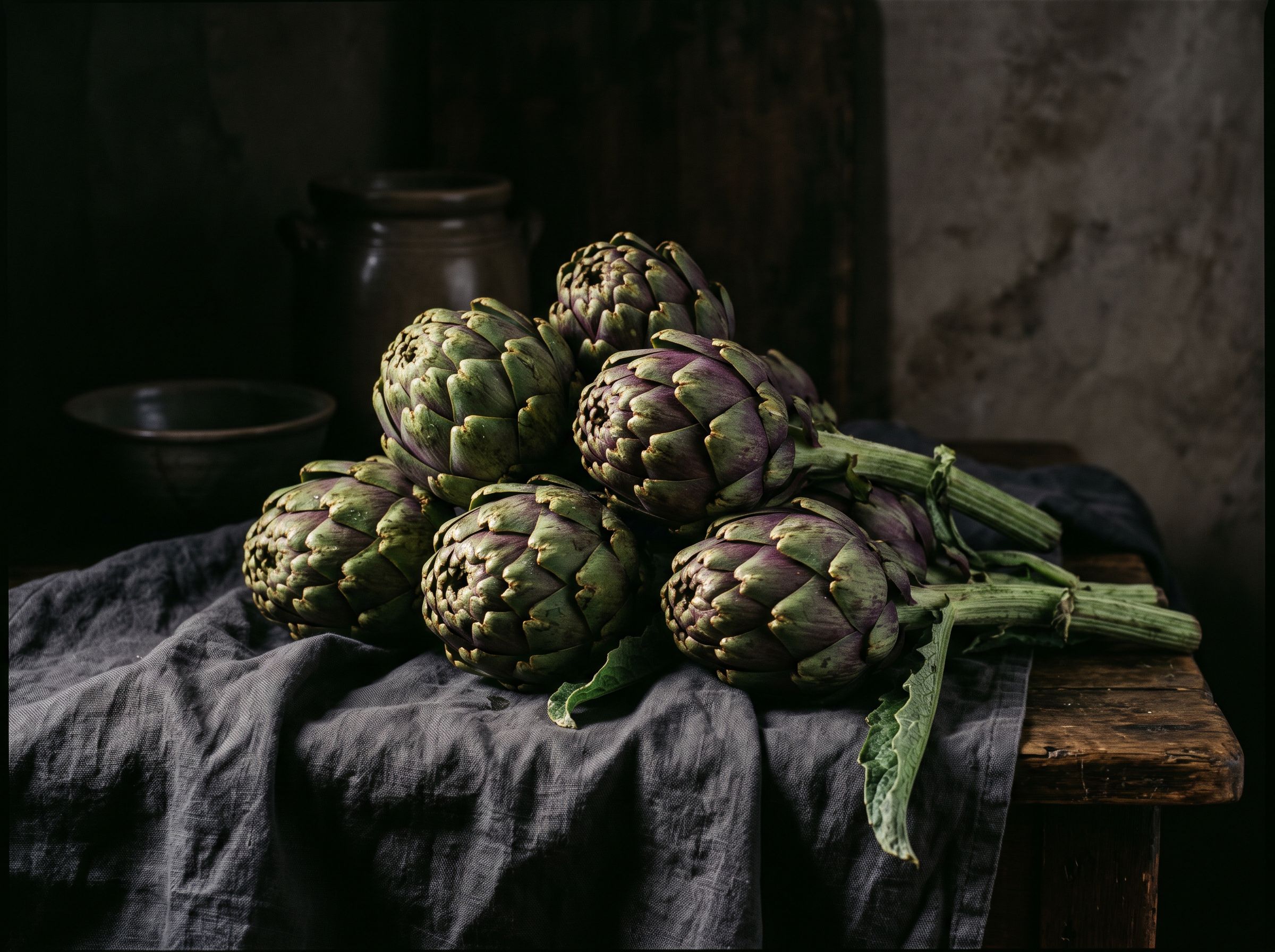 Dark chiaroscuro still life of artichokes